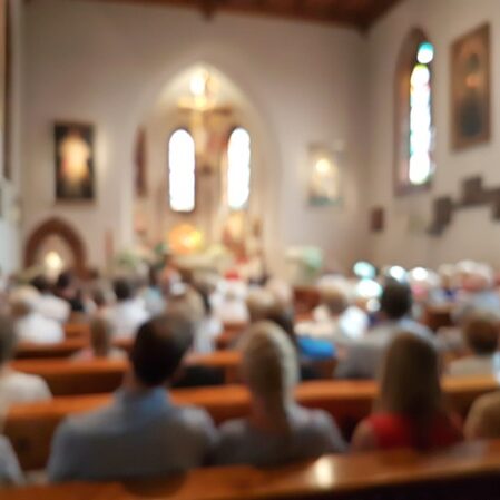 Blurred photo of praying people in the church for abstract background